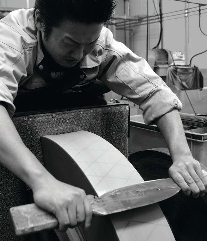 A Shun craftsman grinding a kitchen knife blade